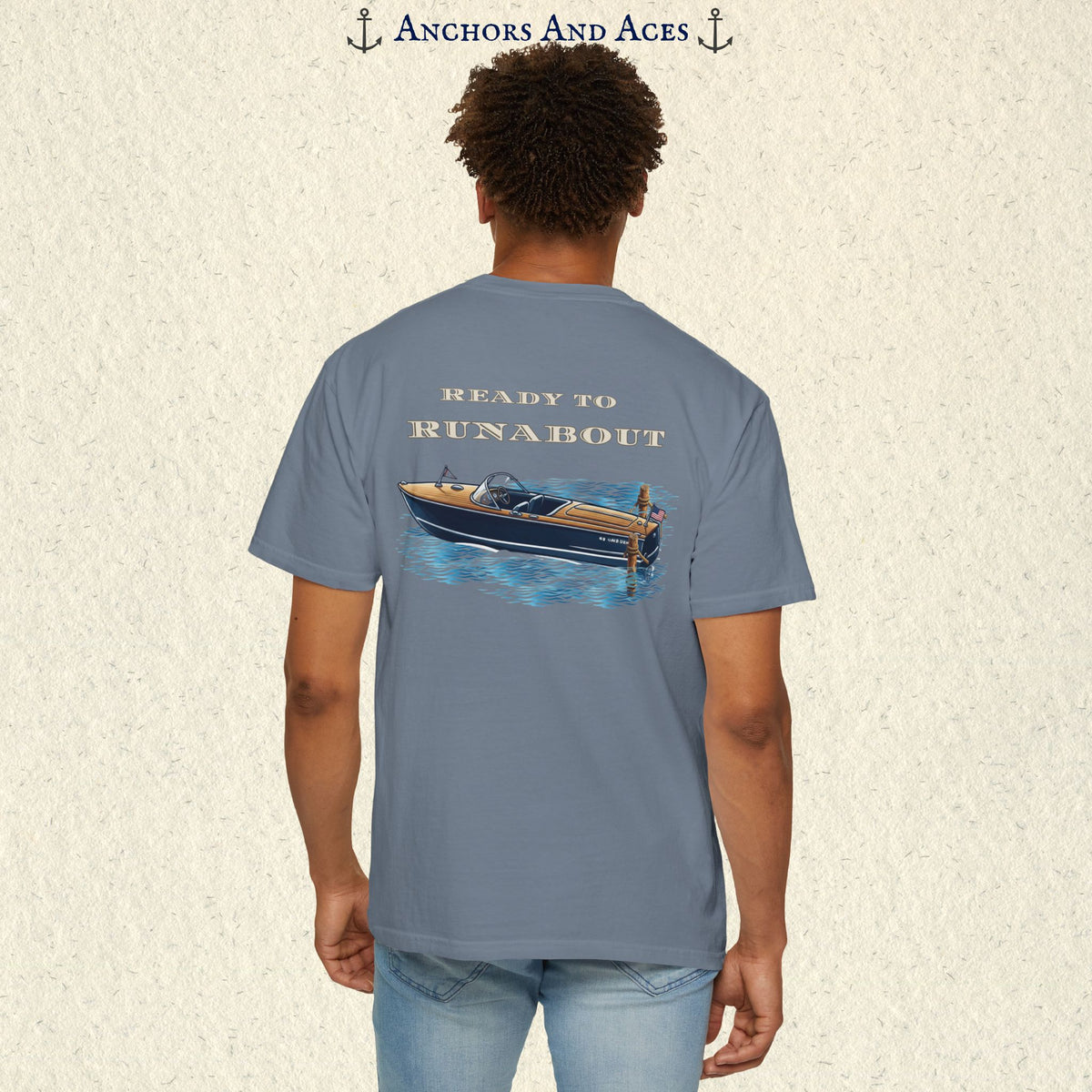 Model wearing a Blue Jean classic wooden boat T-shirt from the back, featuring a vintage runabout on reflective blue water with Ready to Runabout text.