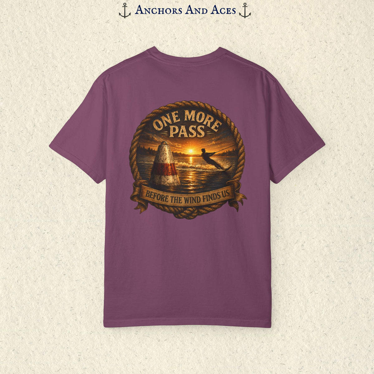 Berry purple vintage slalom water ski T-shirt shown from the back with a sunrise lake graphic featuring a slalom buoy, water skier, rope border, and the text One More Pass and Before the Wind Finds Us.