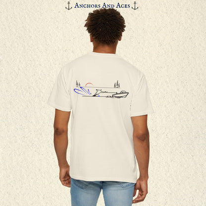 Model wearing a Ivory Comfort Colors 1717 water ski t-shirt from the back, featuring minimalist line art of a ski boat pulling a slalom water skier at sunrise with pine trees and blue spray.