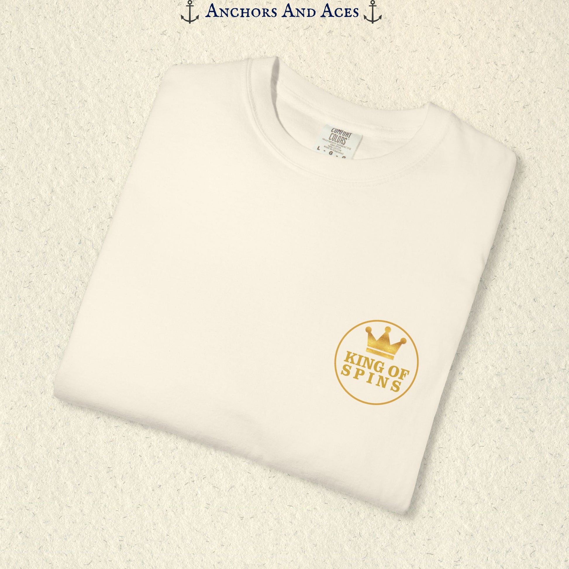 Folded Ivory Slot King T-shirt showing the small gold King of Spins chest emblem.