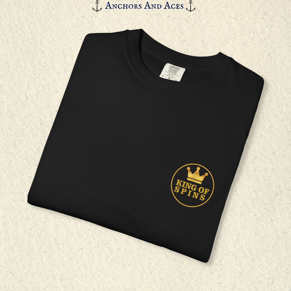 Folded Black Slot King T-shirt showing the small gold King of Spins chest emblem.