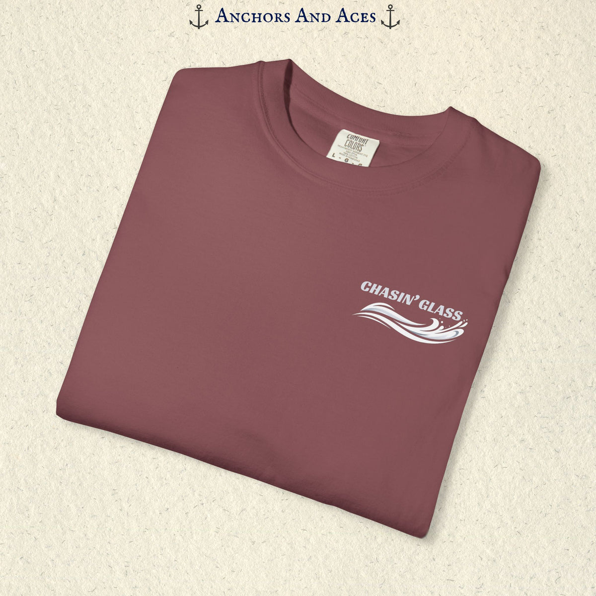Folded Brick red T-shirt showing the small white Chasin' Glass text and stylized water splash logo on the left chest.