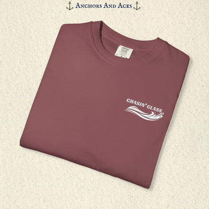 Folded Brick red T-shirt showing the small white Chasin' Glass text and stylized water splash logo on the left chest.