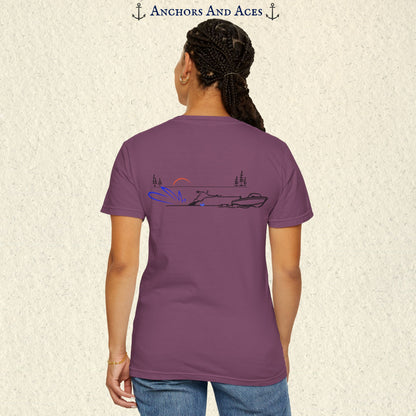 Model wearing a Berry Comfort Colors 1717 water ski t-shirt from the back, featuring minimalist line art of a ski boat pulling a slalom water skier at sunrise with pine trees and blue spray.
