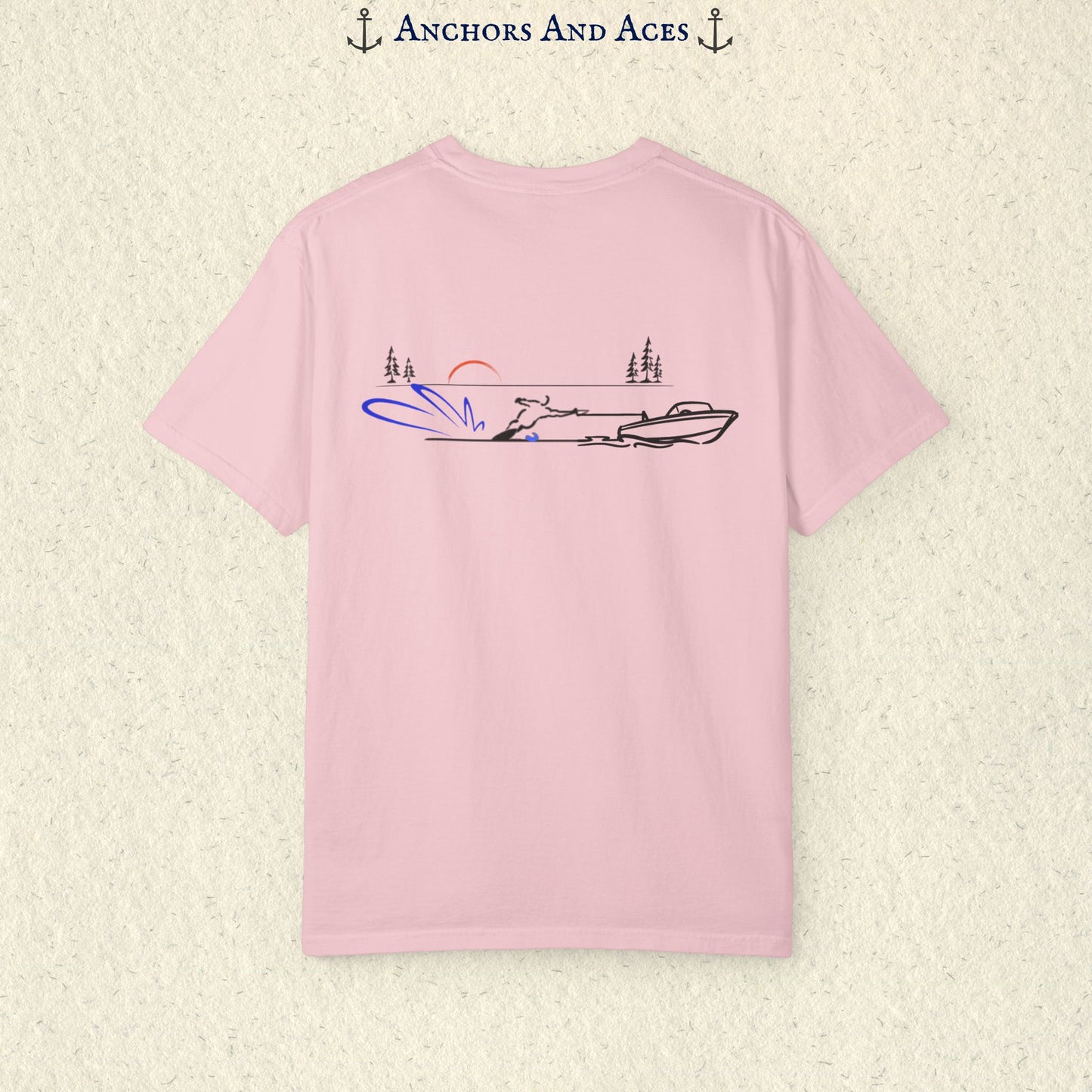 Blossom Comfort Colors 1717 water ski shirt shown from the back, featuring minimalist line art of a ski boat pulling a slalom water skier across calm lake water at sunrise with pine trees and blue spray.