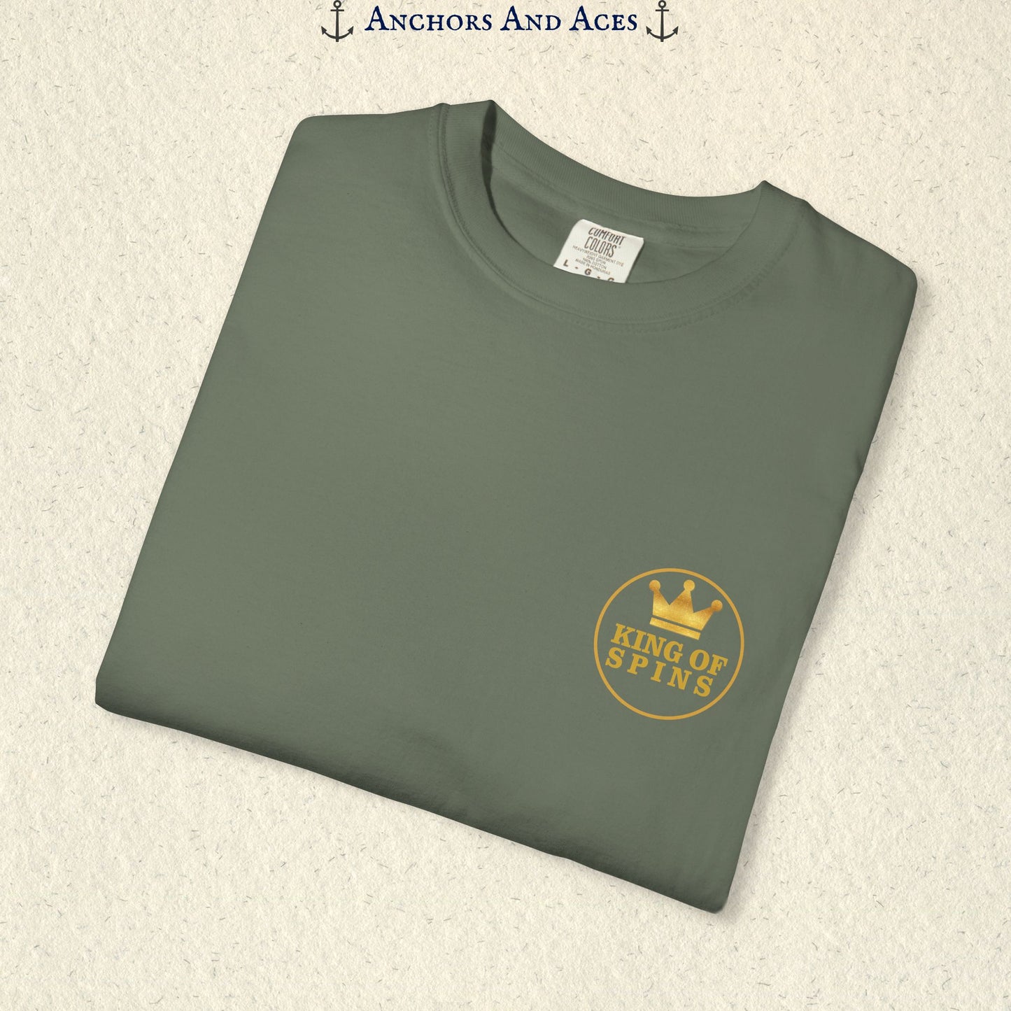 Folded Moss Slot King T-shirt showing the small gold King of Spins chest emblem.