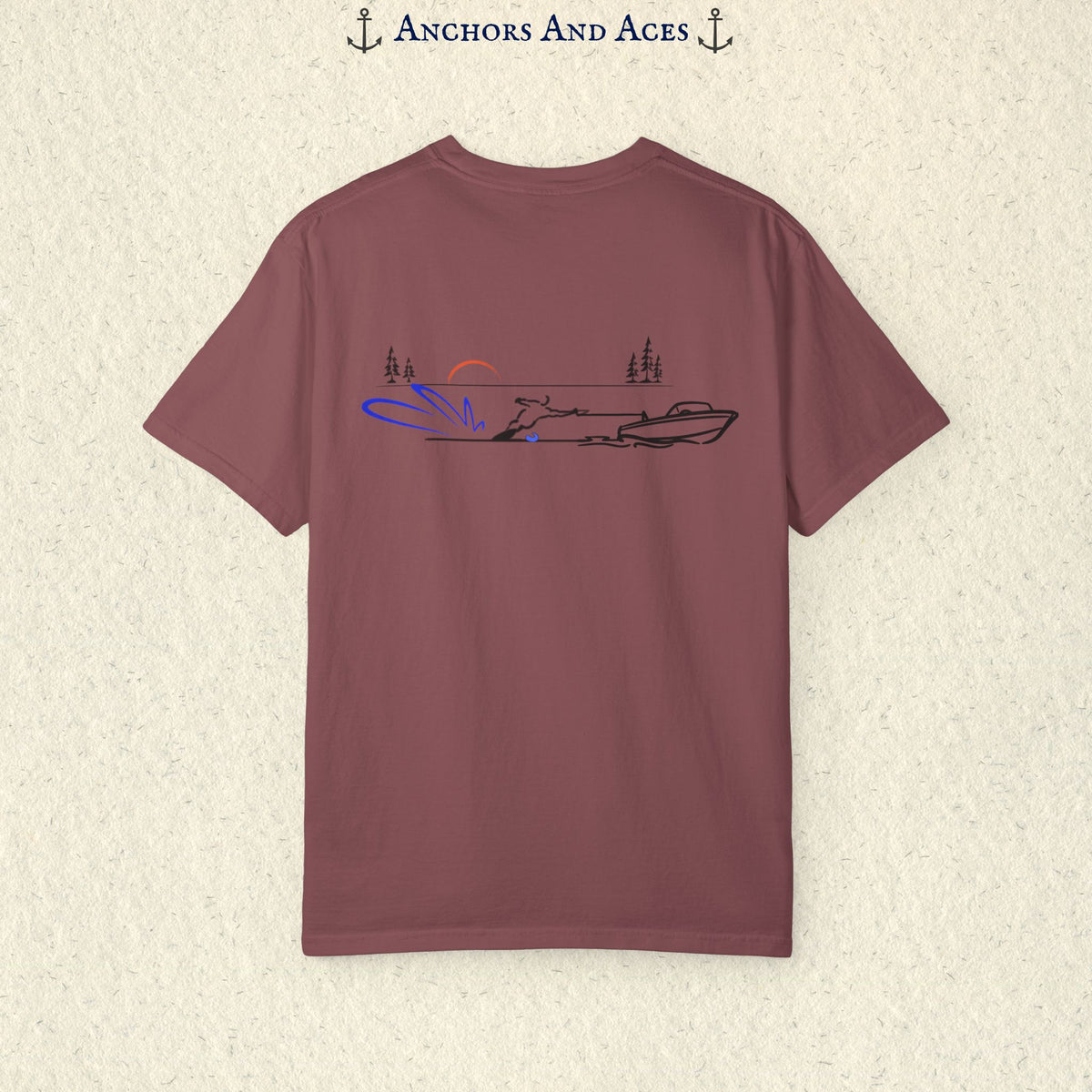 Berry Comfort Colors 1717 water ski shirt shown from the back, featuring minimalist line art of a ski boat pulling a slalom water skier across calm lake water at sunrise with pine trees and blue spray.