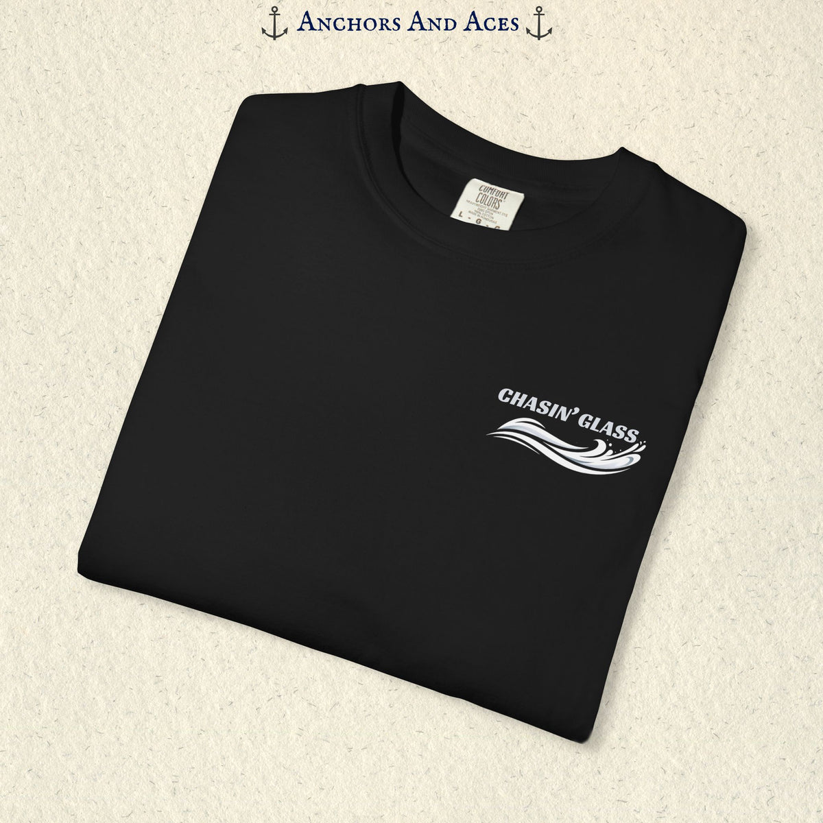 Folded black T-shirt showing the small white Chasin' Glass text and stylized water splash logo on the left chest.