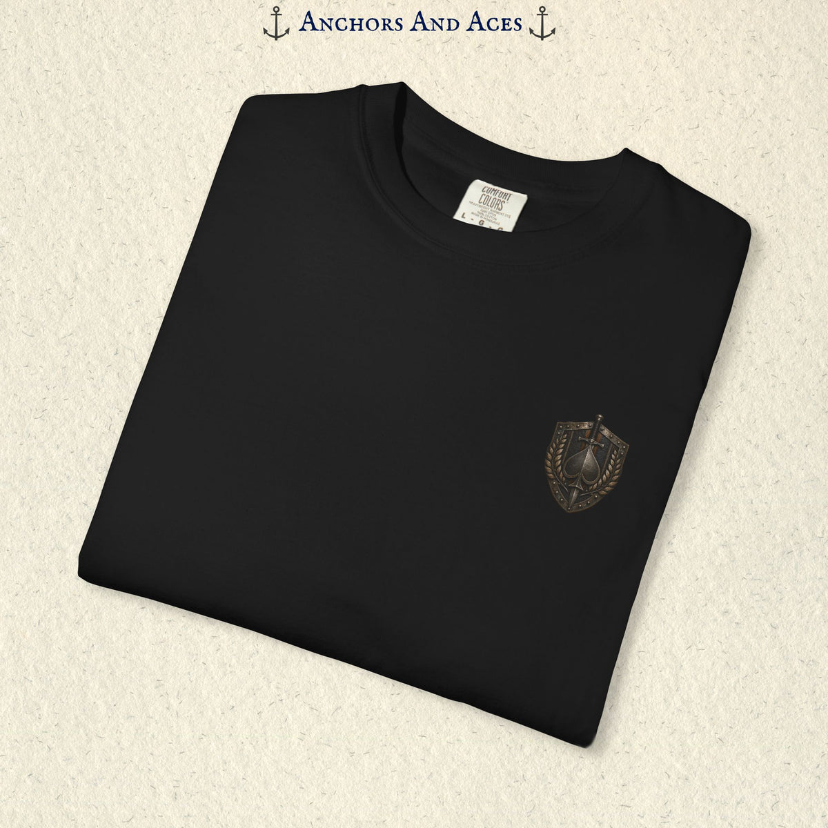 Folded House of Spades graphic tee showing the small medieval-inspired heraldic crest emblem on the front.