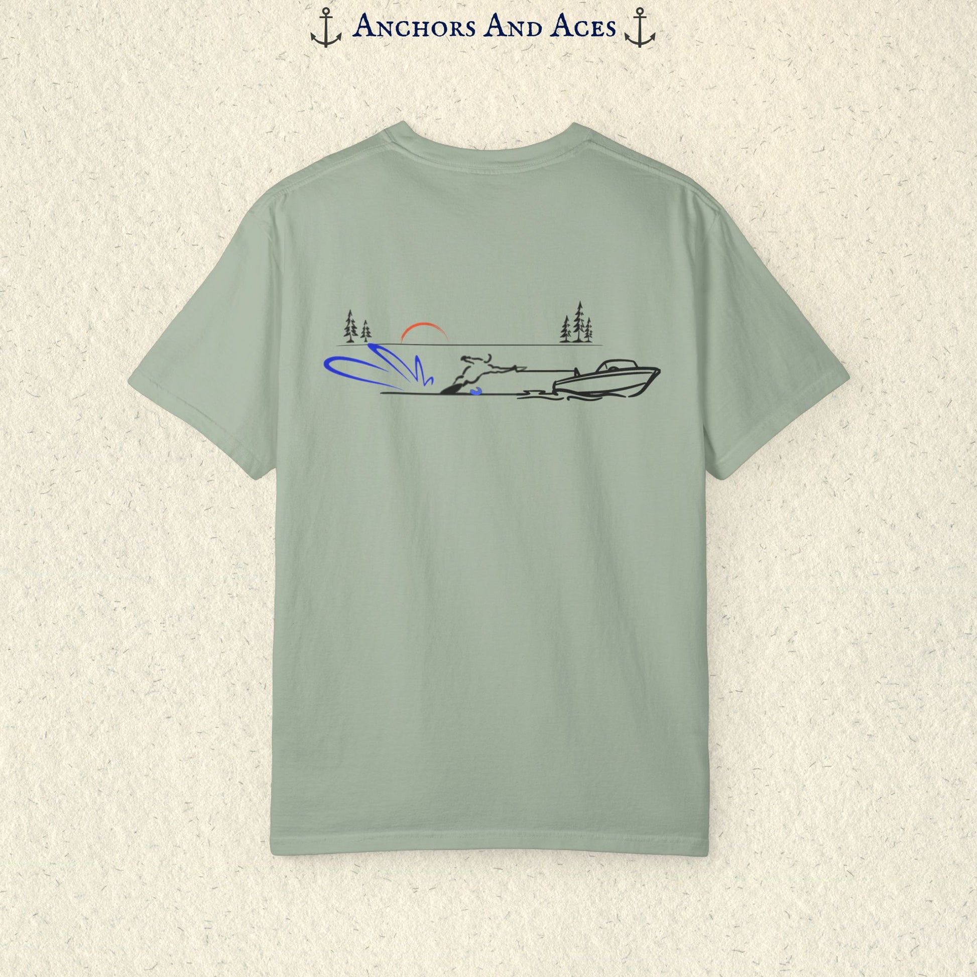 Bay Comfort Colors 1717 water ski shirt shown from the back, featuring minimalist line art of a ski boat pulling a slalom water skier across calm lake water at sunrise with pine trees and blue spray.