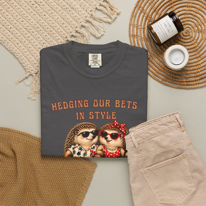 Personalized hedgehog gambling tee in a lifestyle flat lay featuring casino couple artwork and Hedging Our Bets in Style text.