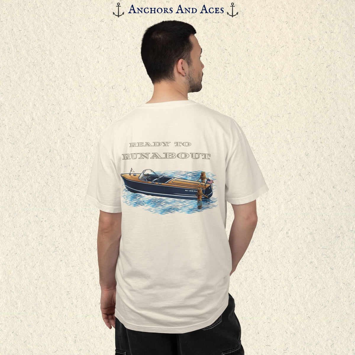 Model wearing a Ivory classic wooden boat T-shirt from the back, featuring a vintage runabout on reflective blue water with Ready to Runabout text.