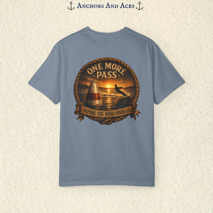 Blue Jean blue vintage slalom water ski T-shirt shown from the back with a sunrise lake graphic featuring a slalom buoy, water skier, rope border, and the text One More Pass and Before the Wind Finds Us.