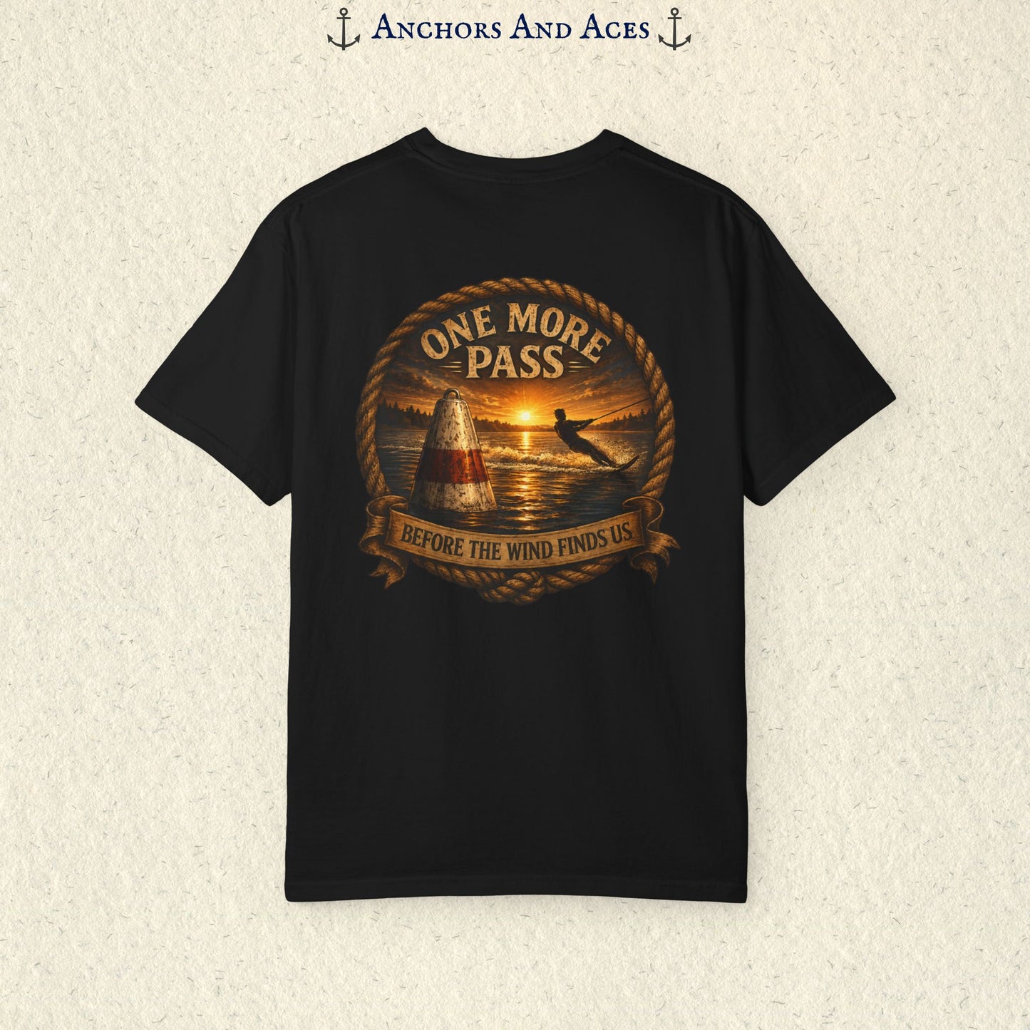 black vintage slalom water ski T-shirt shown from the back with a sunrise lake graphic featuring a slalom buoy, water skier, rope border, and the text One More Pass and Before the Wind Finds Us.