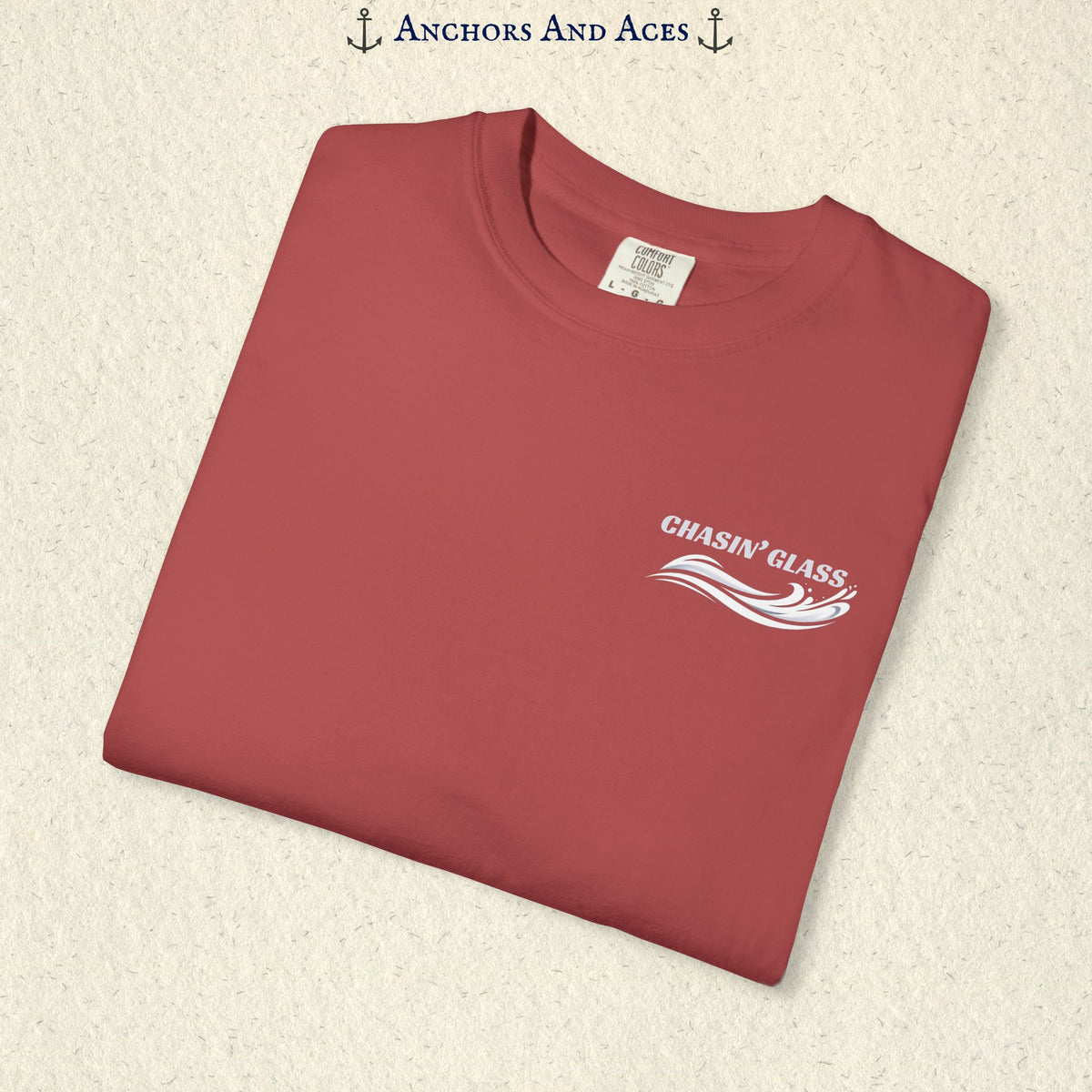 Folded Crimson Comfort Colors 1717 t-shirt showing the front left-chest Chasin' Glass logo, featuring white lettering above a stylized water-splash graphic.