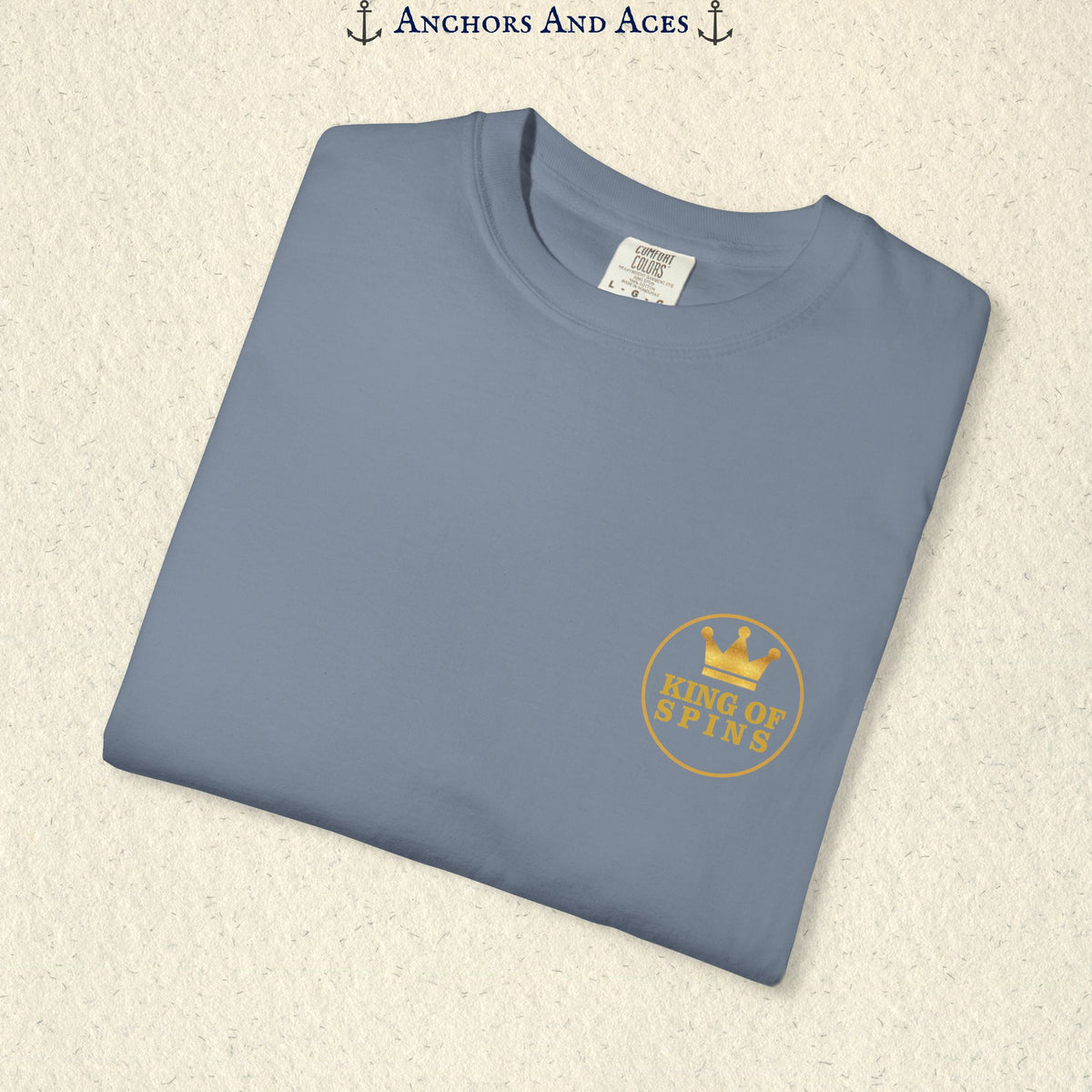 Folded Blue Jean Slot King T-shirt showing the small gold King of Spins chest emblem.