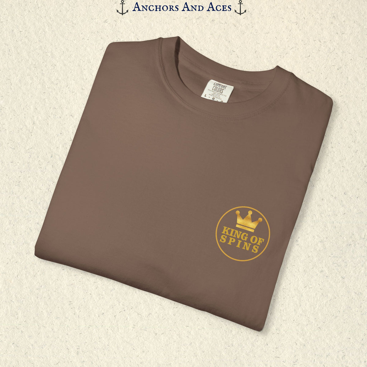 Folded Espresso Slot King T-shirt showing the small gold King of Spins chest emblem.