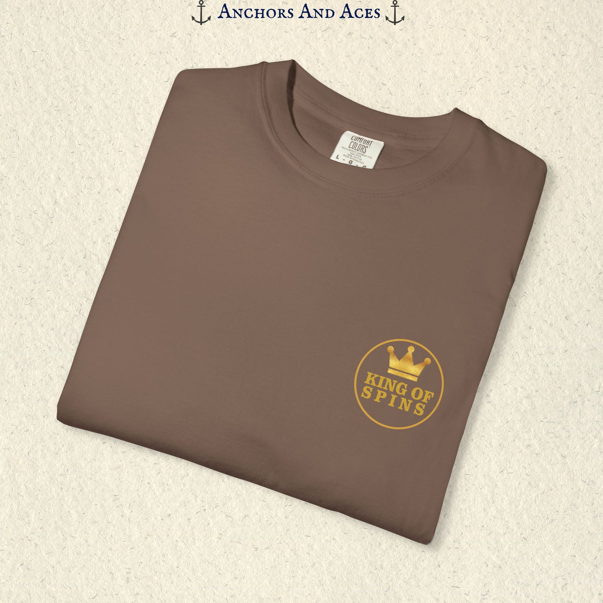 Folded Espresso Slot King T-shirt showing the small gold King of Spins chest emblem.