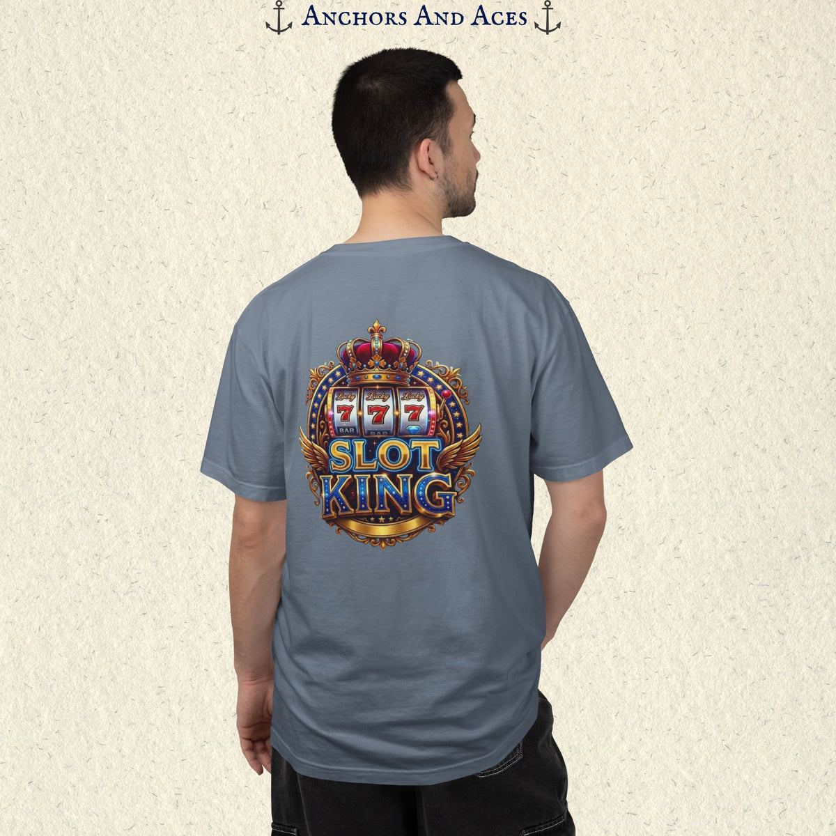Man wearing a Blue Jean Slot King T-shirt with the crowned 777 slot machine artwork on the back.