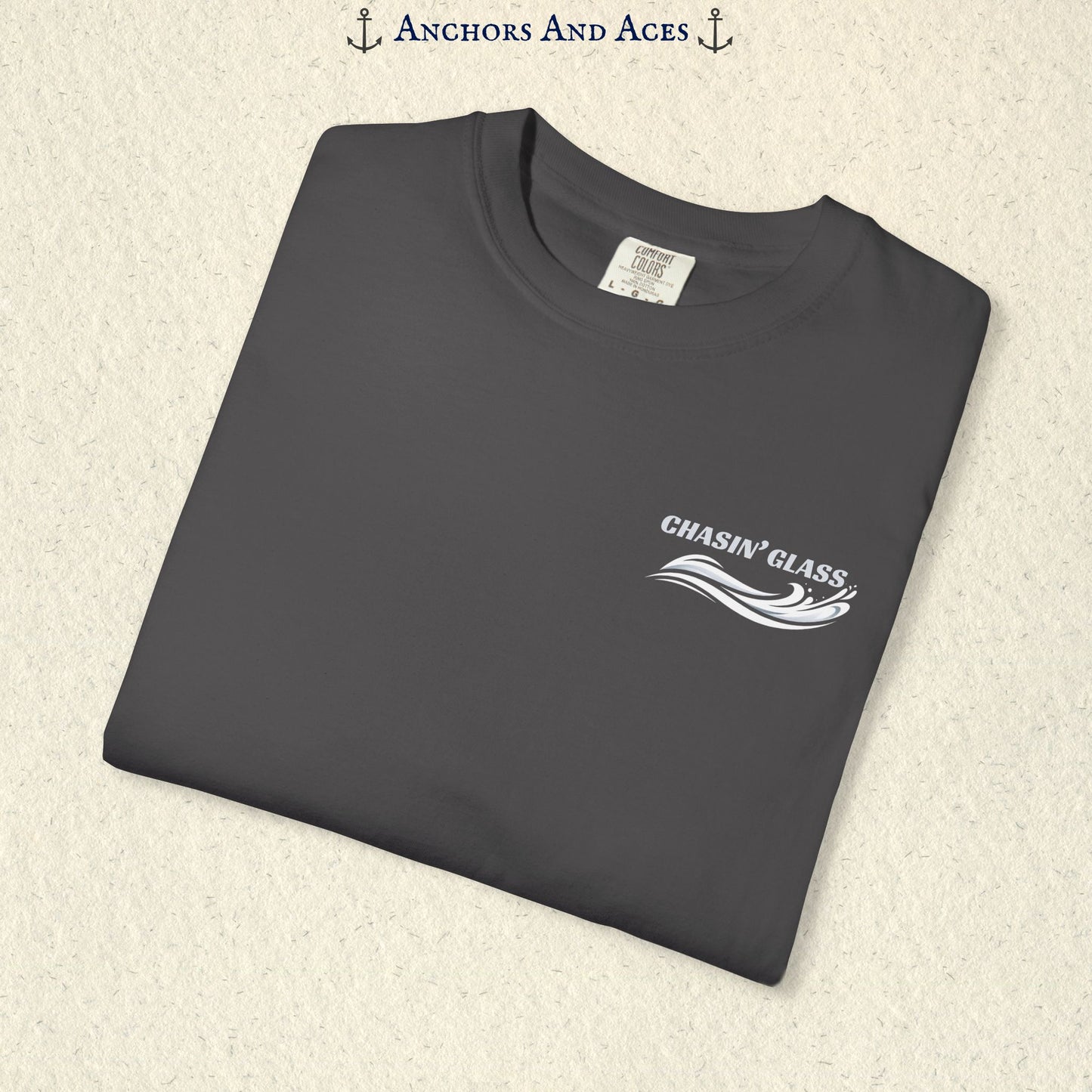 Folded Graphite gray T-shirt showing the small white Chasin' Glass text and stylized water splash logo on the left chest.