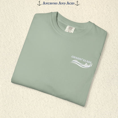 Folded Bay Comfort Colors 1717 t-shirt showing the front left-chest Chasin' Glass logo, featuring white lettering above a stylized water-splash graphic.